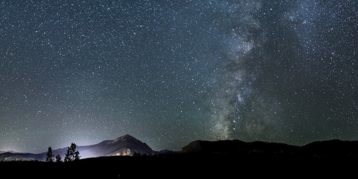 Landscape of desert and stars in sky at night